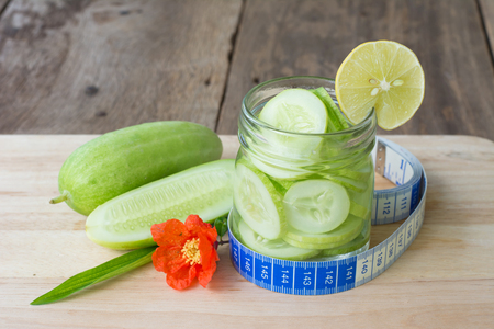 Fresh water with cucumber and lemon in glass on wooden background,healthy foodの写真素材