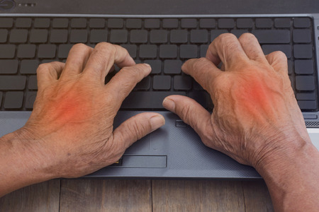 Senior women put a finger on a computer keyboard, she painful finger due to prolonged use of keyboardの写真素材