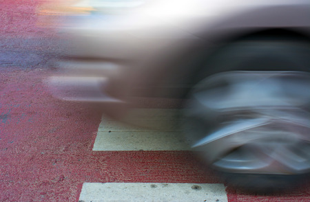 side view of  car in turn with heavy blurred motion on crosswalk