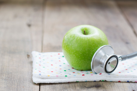 Apple and stethoscope on wooden backgroundの写真素材