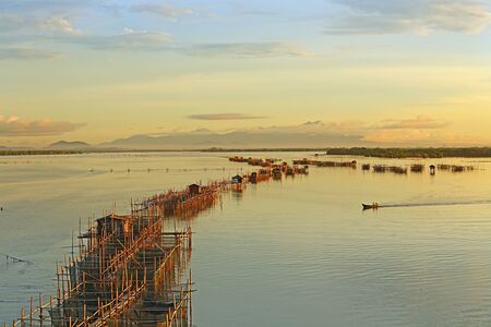 View of aquaculture with fishing boats sailing at morning light in Chanthaburi province of Thailand