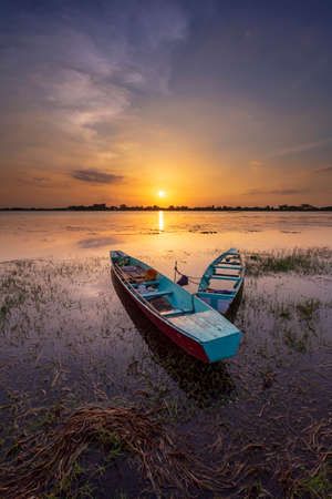 Beautiful view of fishing boats parked in reservoir with during sunset, In the northeast of Thailand