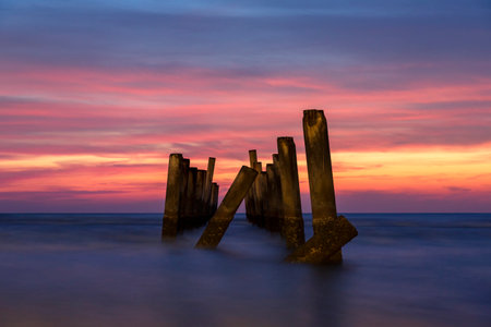 Wooden breakwaters on the beach at sunset. Long exposure.