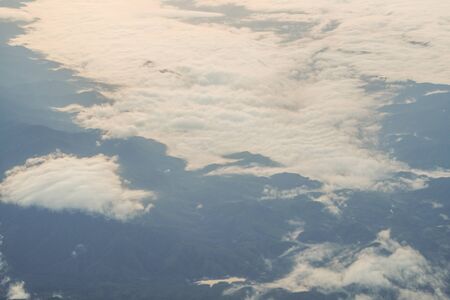Beautiful clouds above the moutain view from airplane perspective.の写真素材