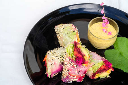 The exotic fresh rolls rice wrappers stuff with mix salad,herbs and fruits served with passionfruit dippingの写真素材