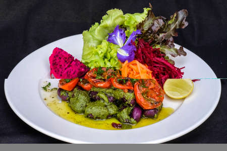 Homemade sweet potato Gnocchi with pesto sauce seved with mix salad lime dressing.の写真素材