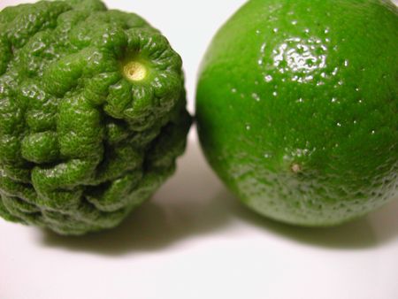 two fresh limes, kaffir and a normal lime on a white background