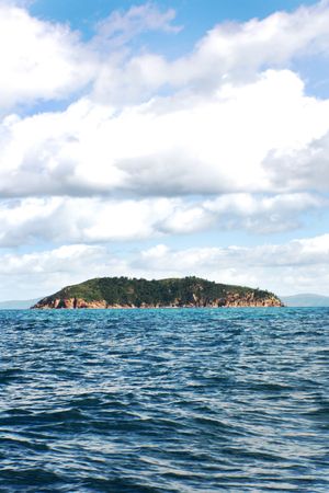 beautiful island view off a boat with clouds in the skyの写真素材