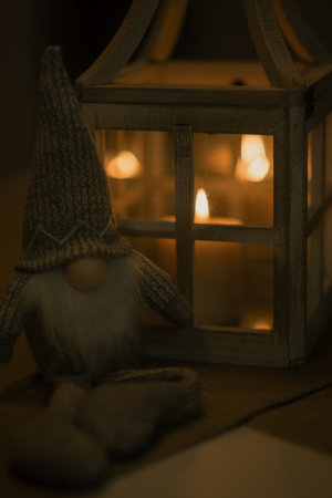 A cute dwarf and a lamp with candles on the tableの写真素材