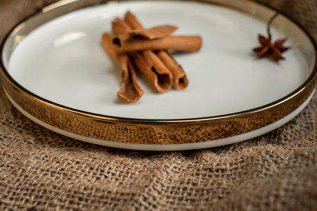 Spices cinnamon and anise on a golden plate, on a background of burlap. Rough texture and composition of spices.の写真素材