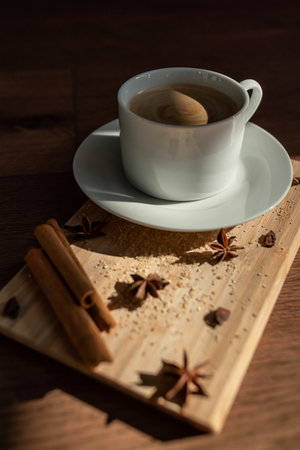 A cup of coffee with cane sugar and cinnamon sticksの写真素材