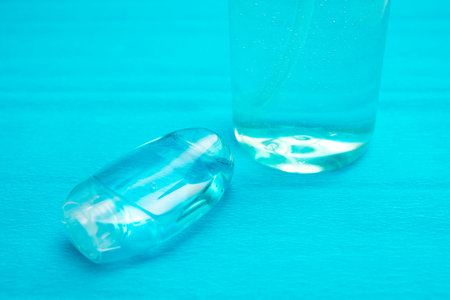 Plastic bottle of the blue transparent liquid soap and a pocket antiseptic gel isolated over the...
