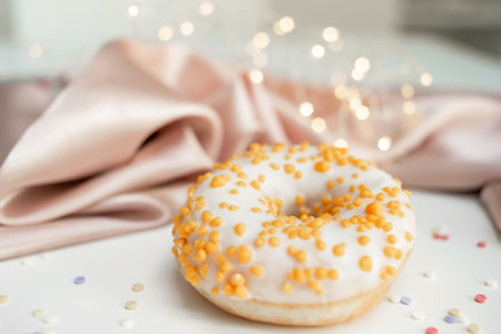 Sweet fresh donut in white glaze on the tableの写真素材