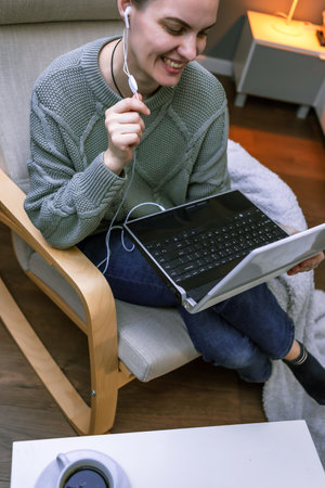 Online consultation psychological, video call with a laptop, a woman in a sweater communicates via video link. Emotional middle aged womanの写真素材