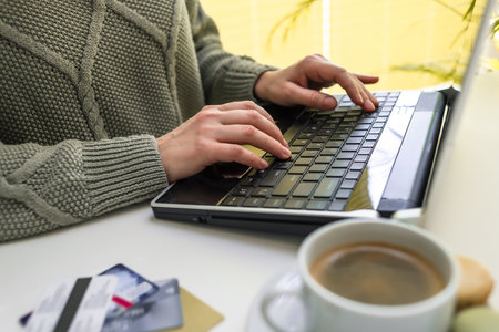 Hands use a laptop, credit cards lie nearby. businesswoman or entrepreneur working from home. Online shopping, e-commerce, internet banking, spending money, work from home conceptの写真素材
