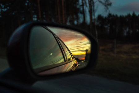 Reflected road in rearview mirror, sunset in the rearview mirror of a carの写真素材
