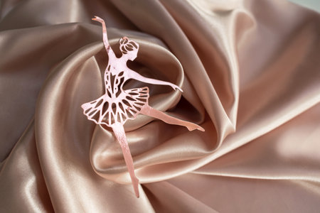 Paper pink ballerina performing a pirouette on a background of pink draped fabric. background pictureの写真素材