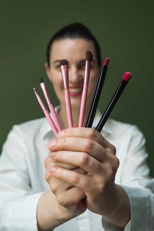 A European woman holds a set of makeup brushes in her hands. A nice Makeup artist with makeup brushes in her hands. A set of makeup brushes in your handsの写真素材