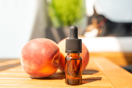 bottle of essential oil. natural cosmetics for skincare. A bottle of whey and fresh peaches on a wooden background. Taking care of health and beautyの写真素材