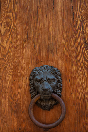 Antique hammer on an antique wooden door. Venice, Italyの写真素材