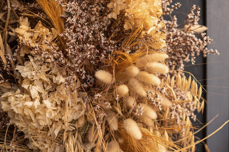 Decor of dried flowers on the wall. A bouquet of dried flowers. Floral minimalist home interior in boho style. The decor of the festive photo zone in the boho style. Selective focus, close-upの写真素材