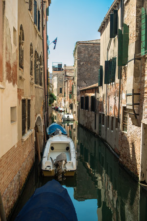 View of the Venetian canal with boats and old houses in flowers. A tourist place, a journey. Venice, Italy, 08.19.2023のeditorial素材