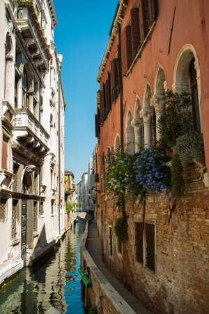 View of the Venetian canal with boats and old houses in flowers. A tourist place, a journey. Venice, Italy, 08.19.2023のeditorial素材