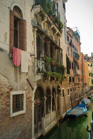 View of the Venetian canal with boats and old houses in flowers. A tourist place, a journey. Venice, Italy, 08.19.2023のeditorial素材