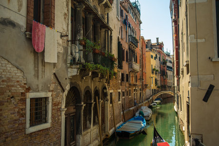 View of the Venetian canal with boats and old houses in flowers. A tourist place, a journey. Venice, Italy, 08.19.2023のeditorial素材