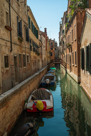 View of the Venetian canal with boats and old houses in flowers. A tourist place, a journey. Venice, Italy, 08.19.2023のeditorial素材
