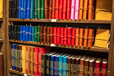 Bookshelves filled with books. Books in colorful leather bindings. Colorful Handmade Notebooks, Close-upの写真素材