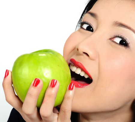 Beautiful young asian girl eating appleの写真素材