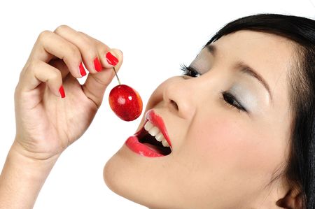 Beautiful young asian girl eating cherryの写真素材