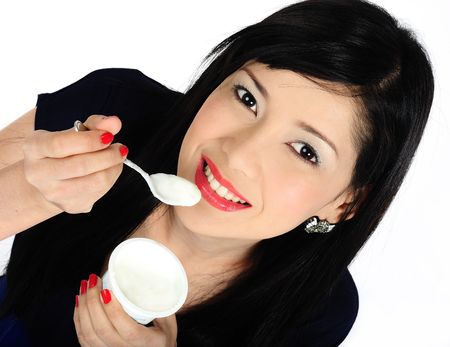 Beautiful young asian girl eating yogurtの写真素材