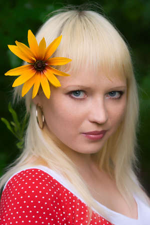 The young girl with a yellow flower close upの写真素材