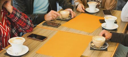Group of people sitting in a bar- Friends drinking coffee and enjoying time- Table and drinks focus