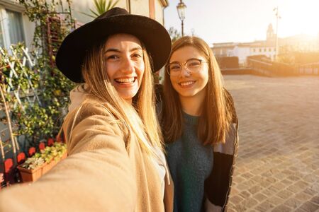 Teenagers takeing selfie in sunset - Girls smiling at the camera and having fun
