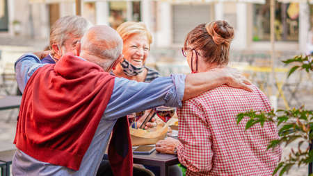 Retired couples hanging out with each other outside drinking wineの写真素材