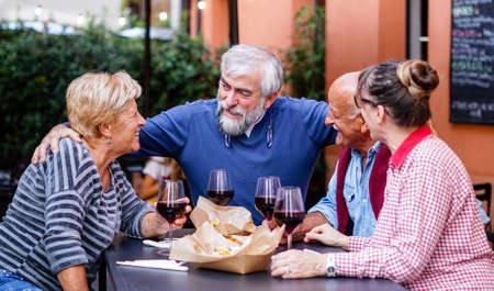 Group of old people eating and drinking outdoor