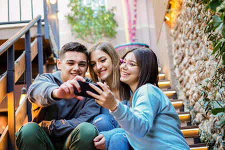 Young people using smartphone together - Students having fun with cellphone