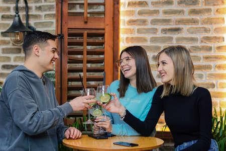 Young people have fun in a bar - Friends drinking cocktails together