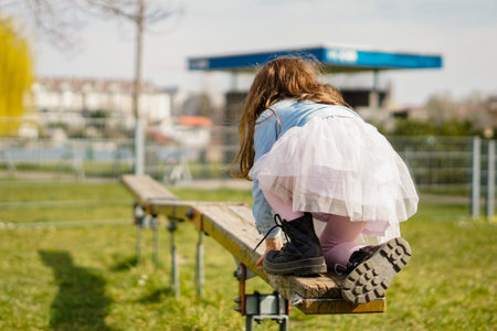 Little girl keeping balance in playground doing fun activities - Kid playing outside in springの写真素材