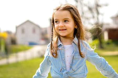 Young girl running outside in spring fresh air - Kid enjoying sunny day in park walking and smilingの写真素材