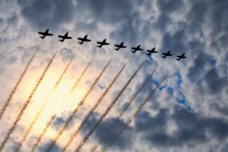 The view of several jet planes in formation on the cloudy sky background.