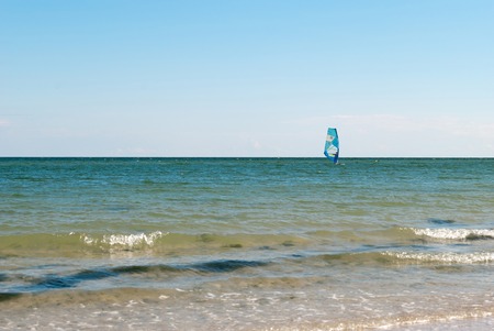 windsurfing, surfing on a board under a sail, wave blue sea, blue sky, summer vacation, seashore, sportの写真素材
