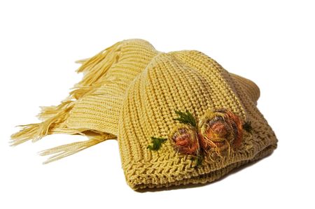 Warm knitted scarf and hat with flowers isolated on white backgroundの写真素材