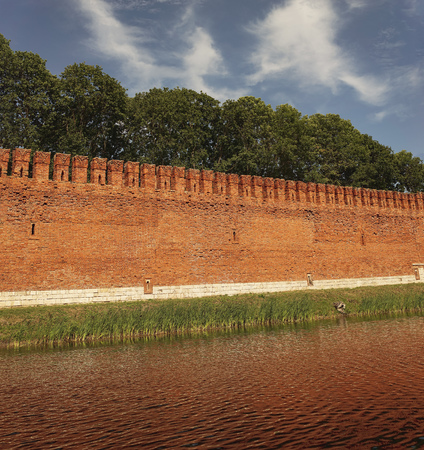 Fortress wall of red brick and moat with water.の写真素材