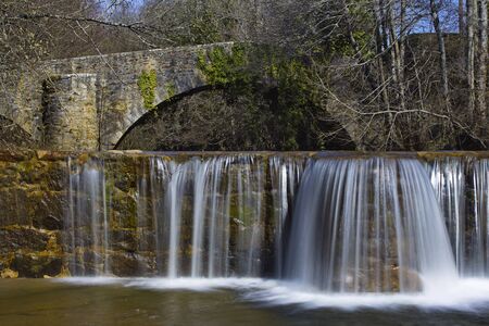 Sarria, Araba/Basque Country; Mar. 18, 2017. Dam and an old bridge over the Bayas river as it passes through Sarria in the Natural Park of Gorbeia.の写真素材
