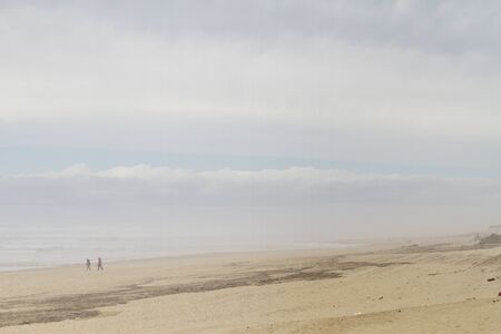 People walking on the beach. Social distancing.の写真素材