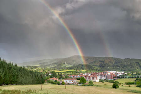 Larrabetzu, Bizkaia / Basque Country; Jun. 11, 2019. Double rainbow with a stormy sky over the town of Larrabetzu.のeditorial素材